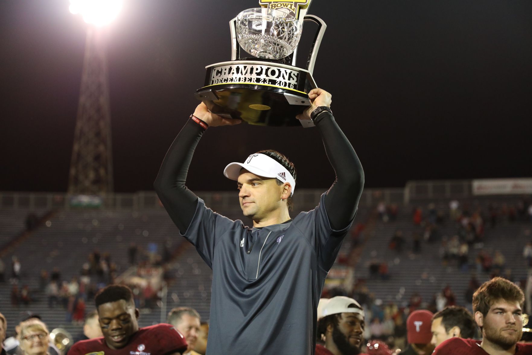 Neal Brown hoists the 2016 Dollar General Bowl trophy following Troy's 28-23 victory over Ohio University.